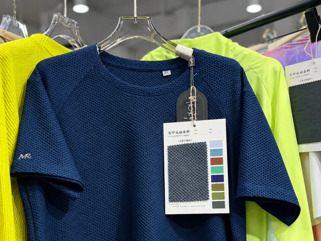 Navy mesh knit garment displayed with a fabric swatch and color reference card